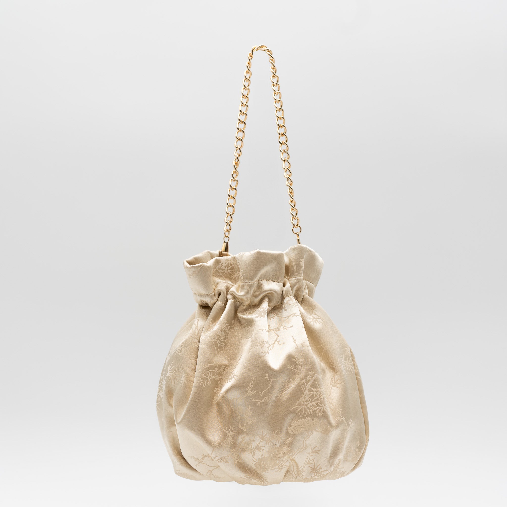 Bolso bombonera de fiesta en raso beige con bordado floral, cierre fruncido y asa de cadena