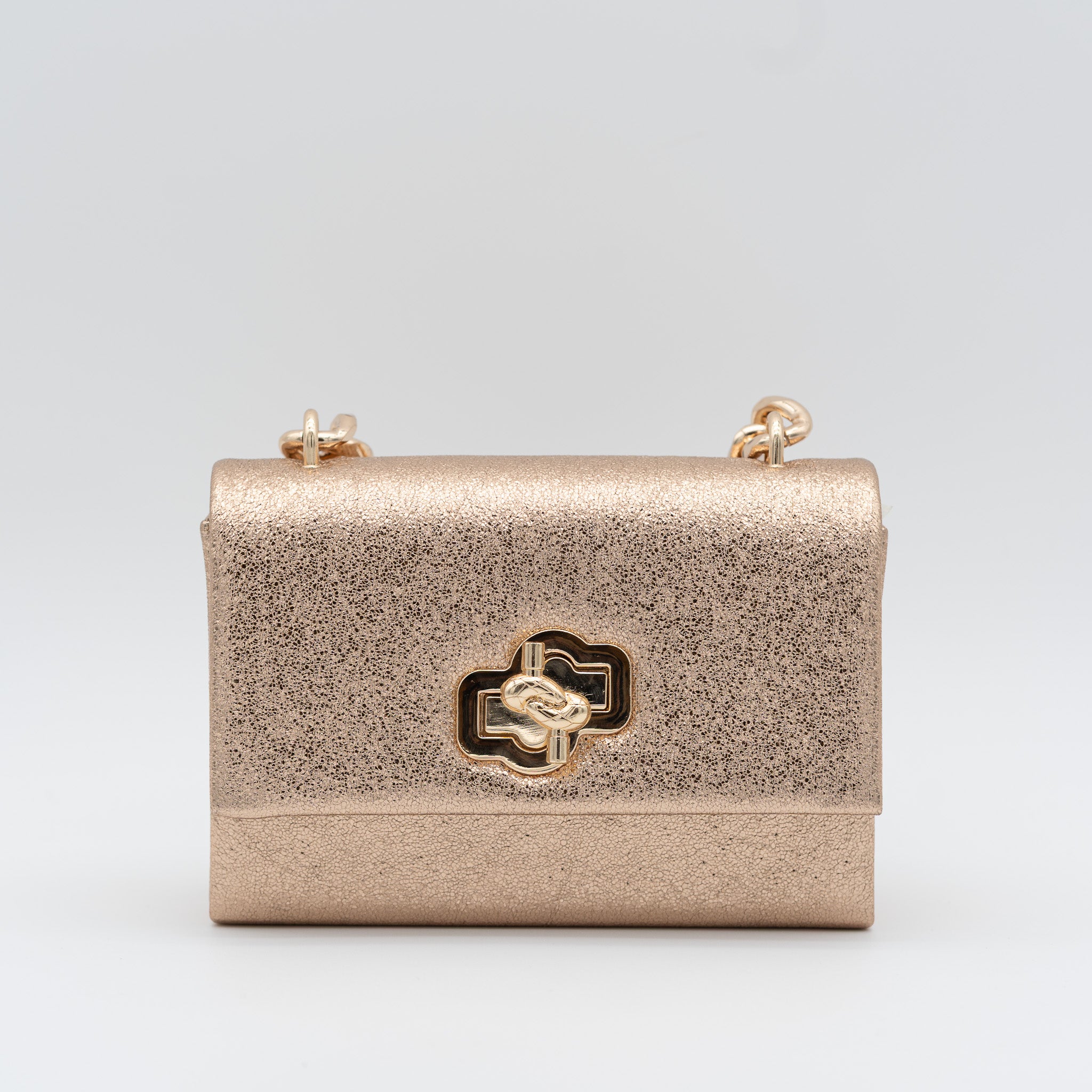 Bolso de fiesta en polipiel champán con acabado brillante, asa de cadena y cierre decorativo, ideal para bodas y cócteles