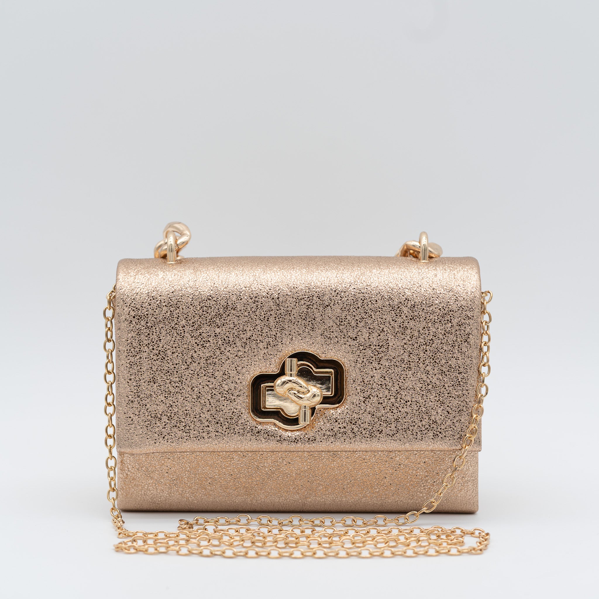 Bolso de fiesta en polipiel champán con acabado brillante, asa de cadena y cierre decorativo, ideal para bodas y cócteles