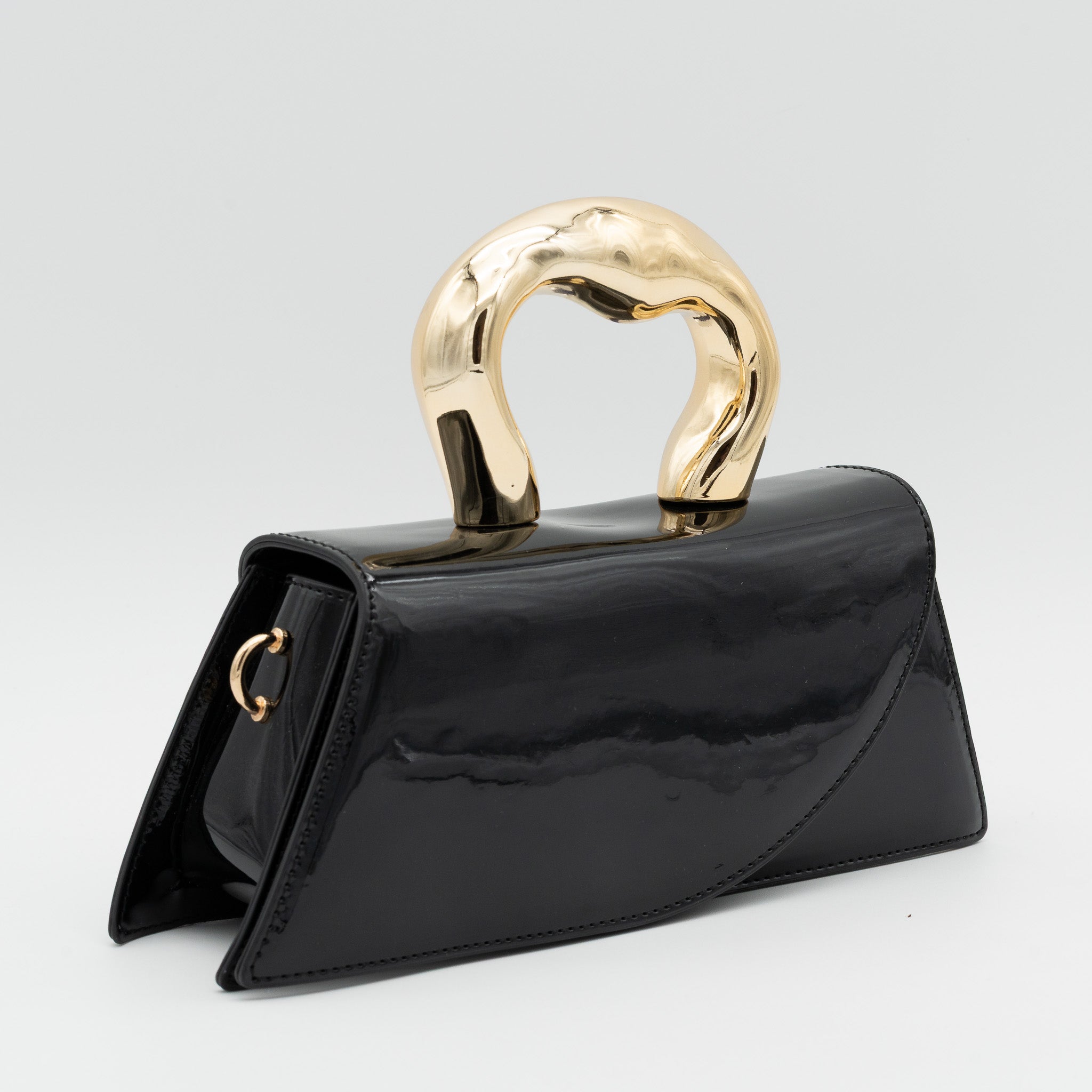 Bolso de fiesta de polipiel con efecto acharolado negro, asa de mano con acabado metálico y cierre imantado