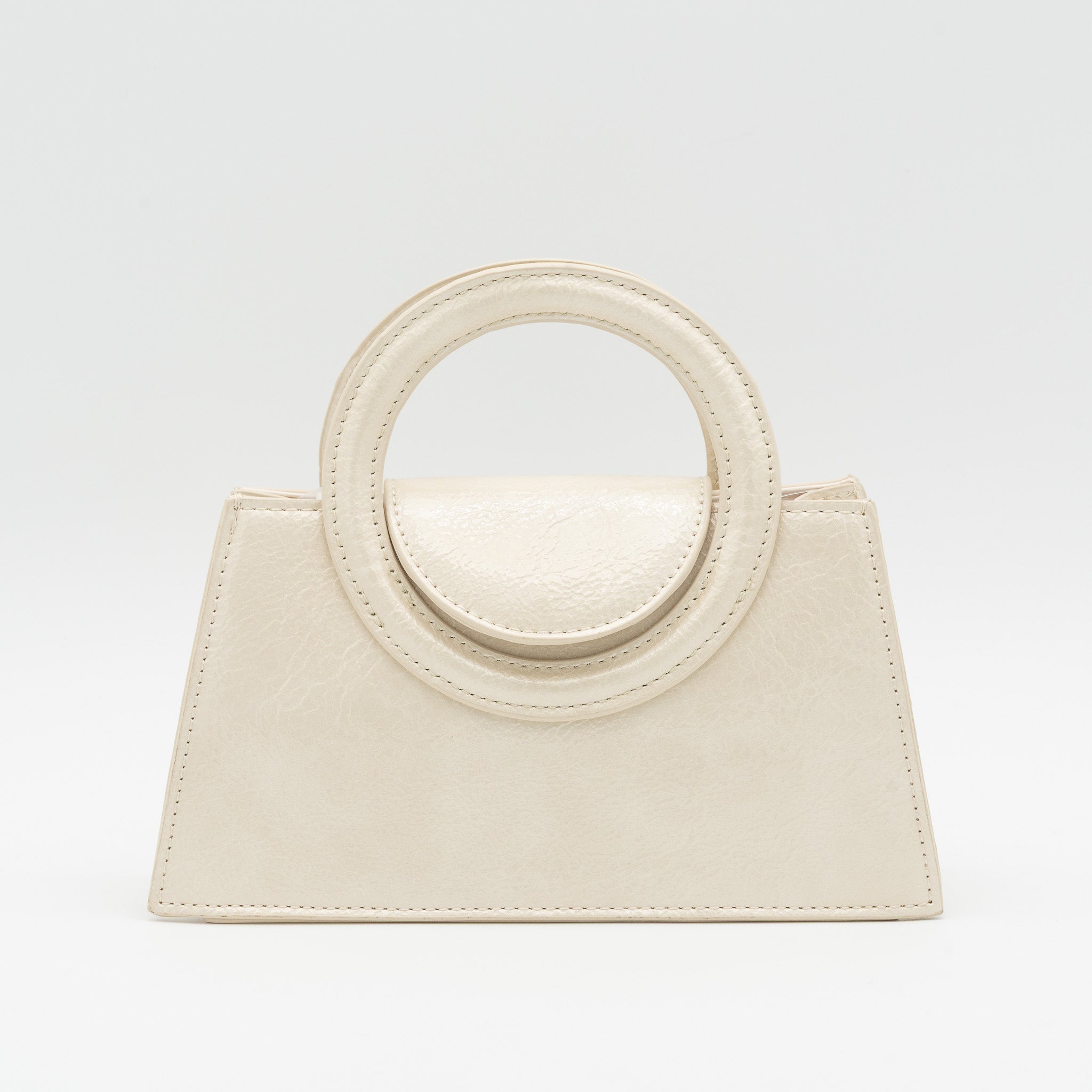Bolso de mano beige acharolado con asa circular rígida y cadena dorada desmontable