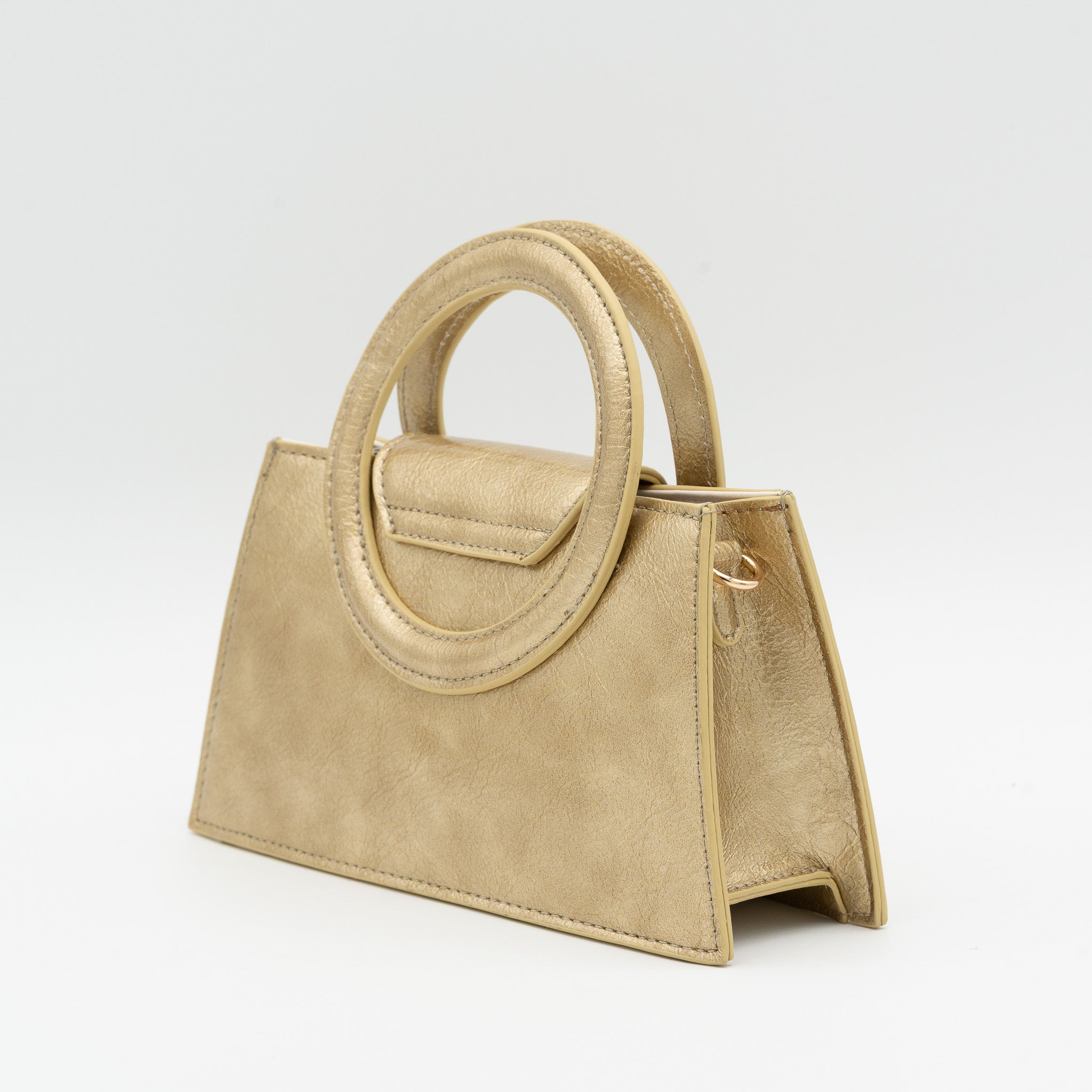 Bolso de mano oro acharolado con asa circular rígida y cadena dorada desmontable