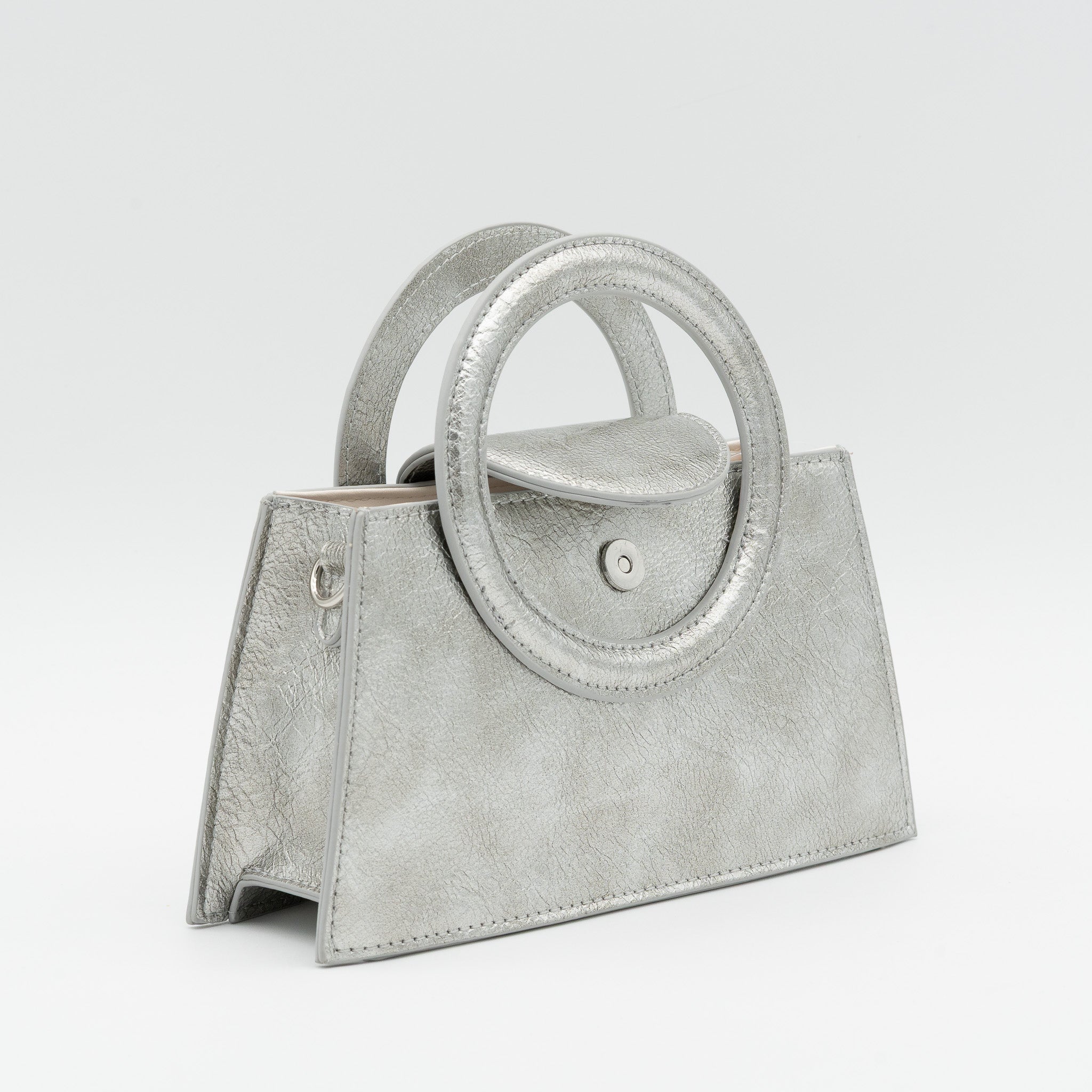 Bolso de mano plata acharolado con asa circular rígida y cadena dorada desmontable
