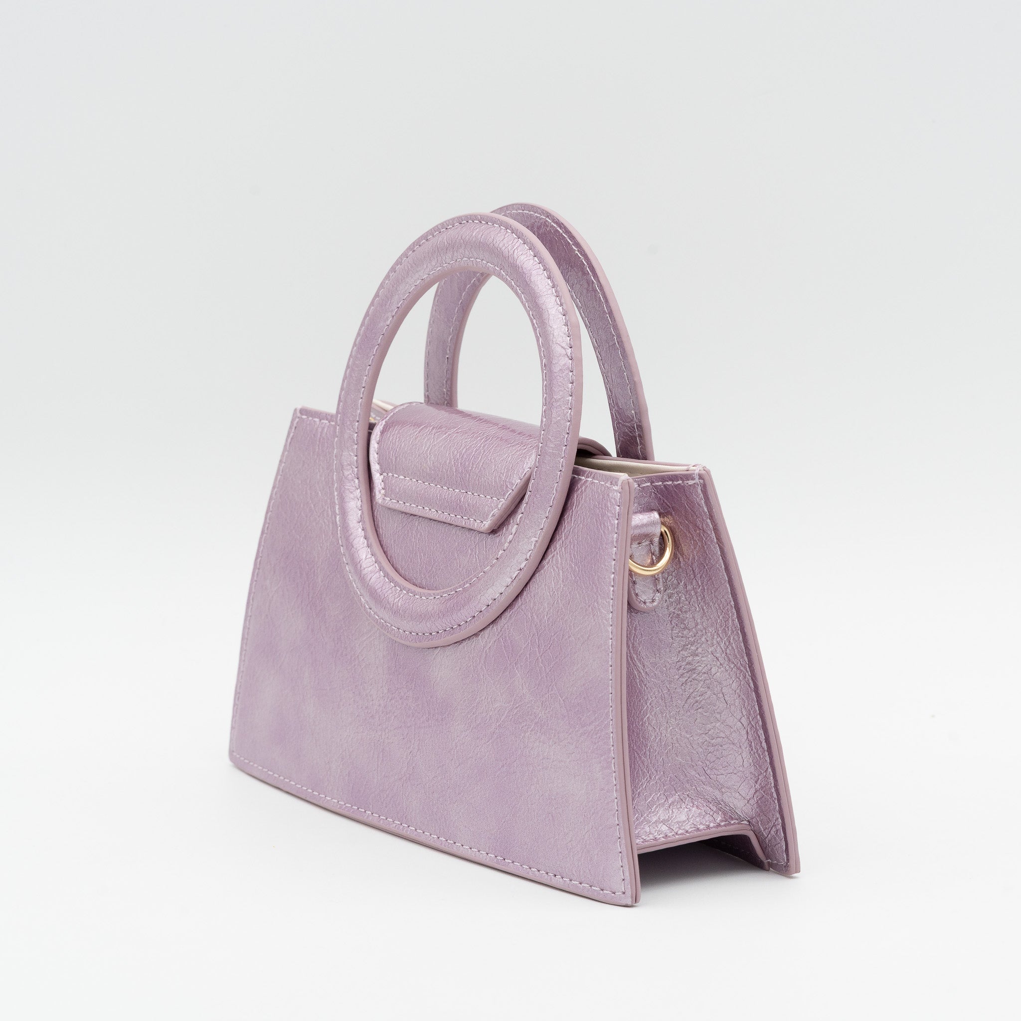 Bolso de mano rosa morado acharolado con asa circular rígida y cadena dorada desmontable