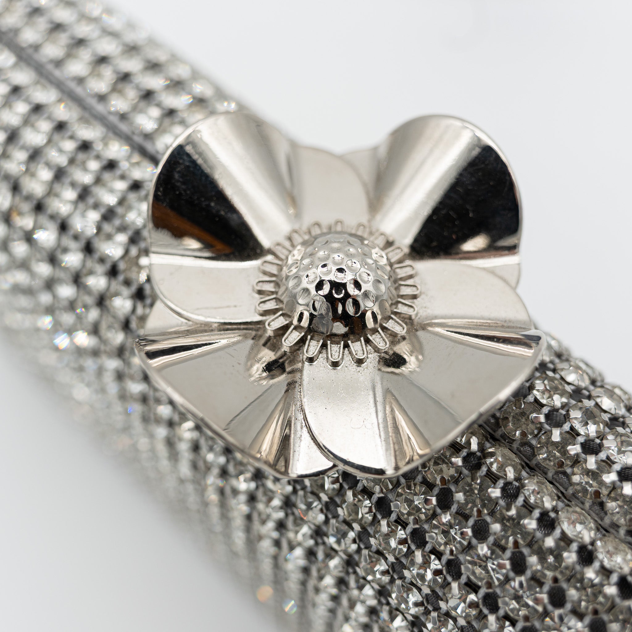 Clutch de fiesta con pedrería plata, cierre en forma de flor y cadena desmontable, ideal para bodas y cócteles