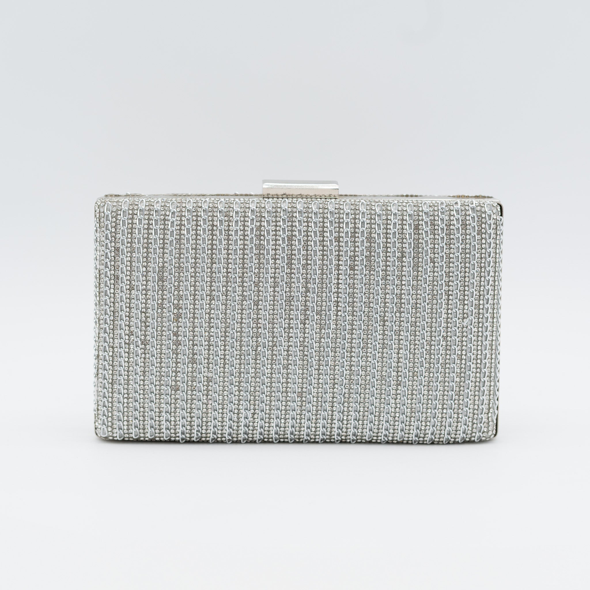 Clutch de fiesta plata con pedrería en líneas, cierre superior y cadena desmontable, ideal para bodas y cócteles