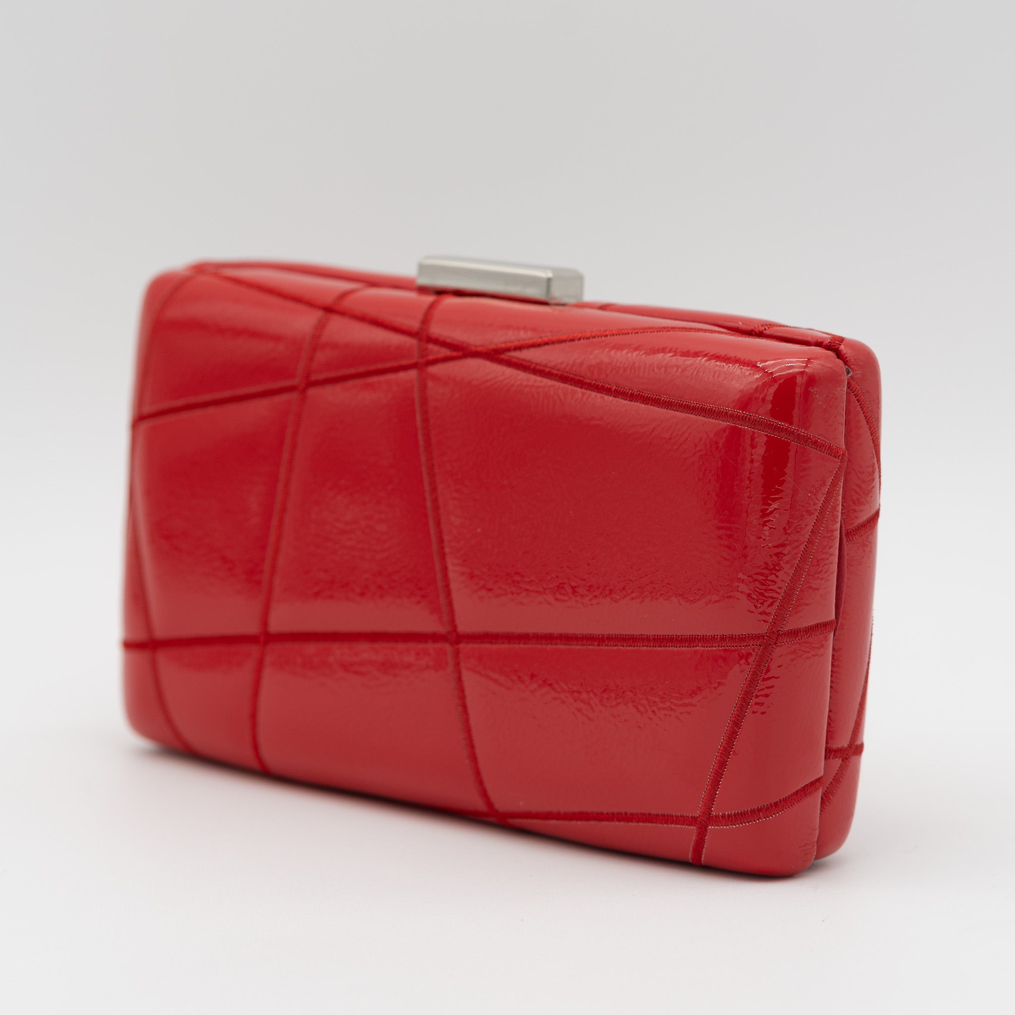 Clutch de fiesta en polipiel rojo con bordado geométrico, efecto acharolado, cierre metálico y cadena desmontable, ideal para bodas y cócteles