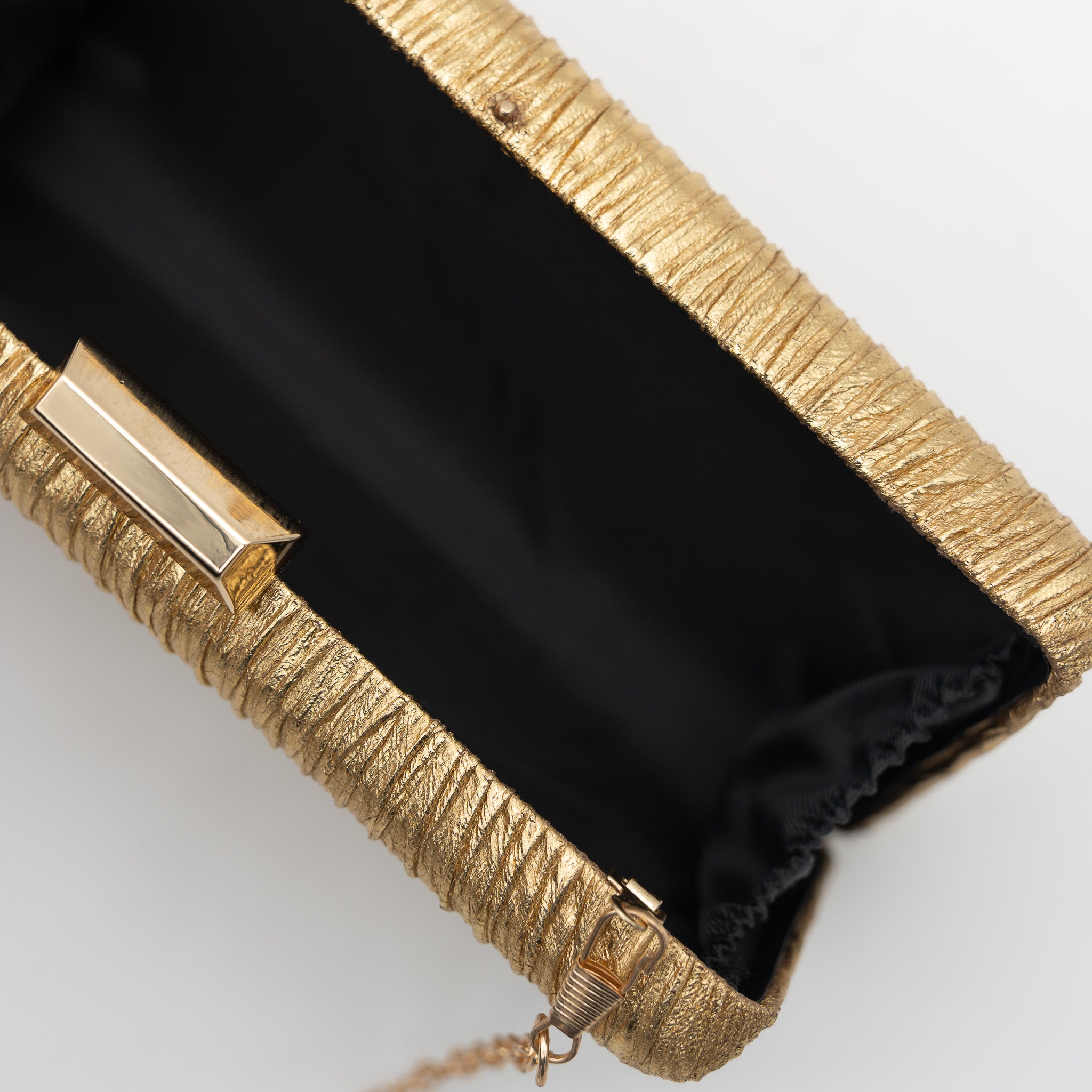 Clutch de fiesta en polipiel con efecto arrugado oro, cierre metálico y cadena desmontable, ideal para bodas y cócteles