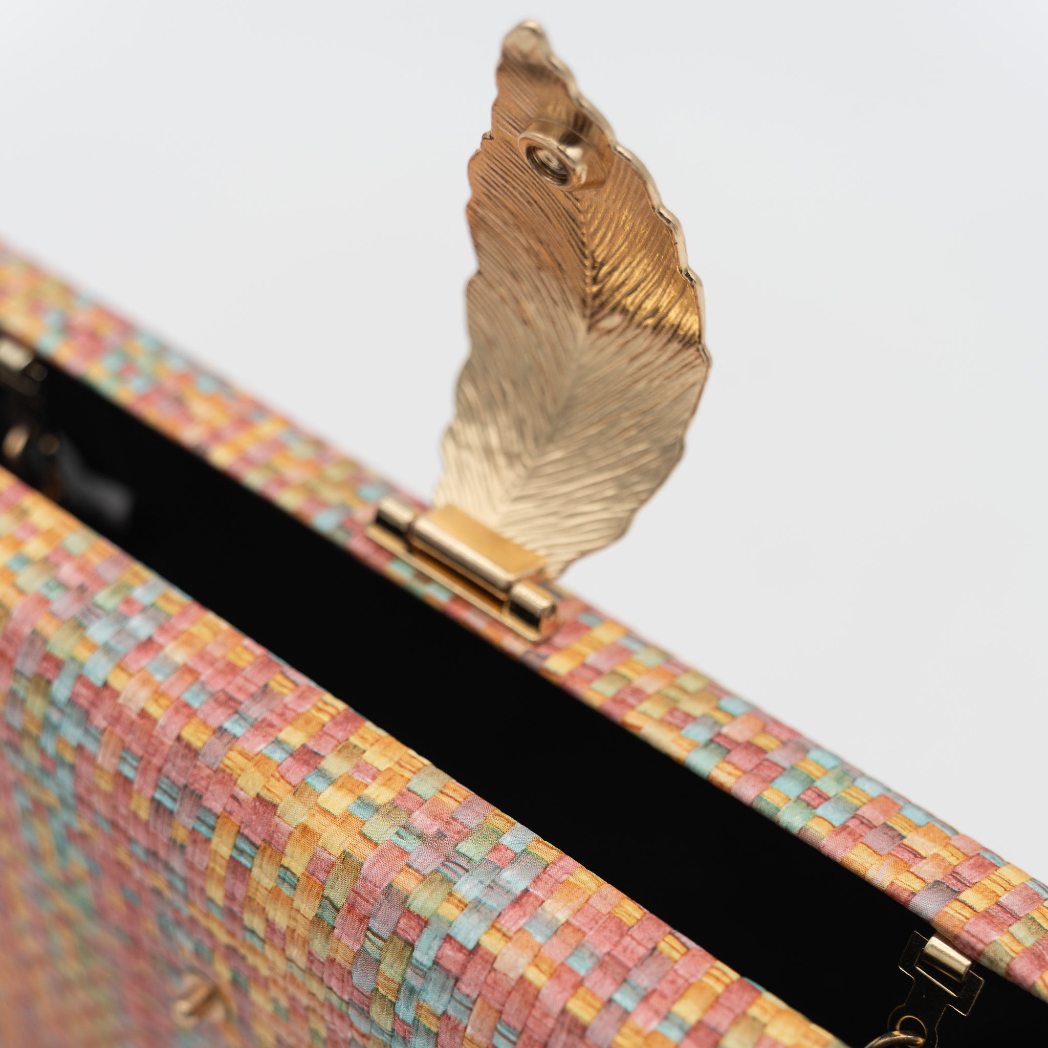 Clutch de fiesta en polipiel multicolor naranja con cierre de hoja metálica y cadena desmontable, ideal para bodas y cócteles