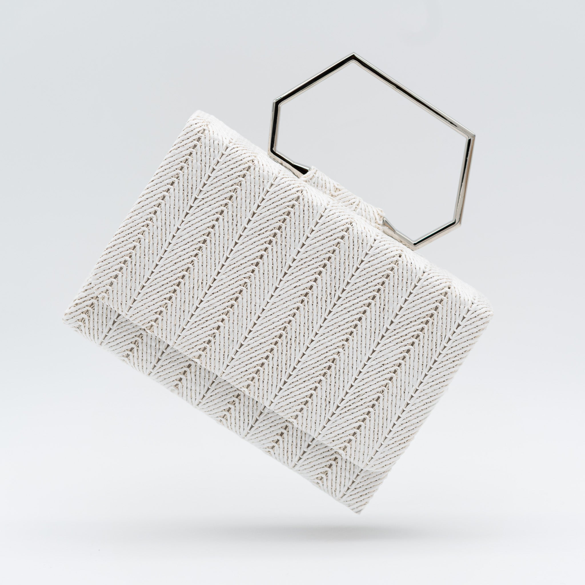 Clutch de fiesta en rafia blanco con asa geométrica metálica y cierre magnético, perfecto para bodas y cócteles