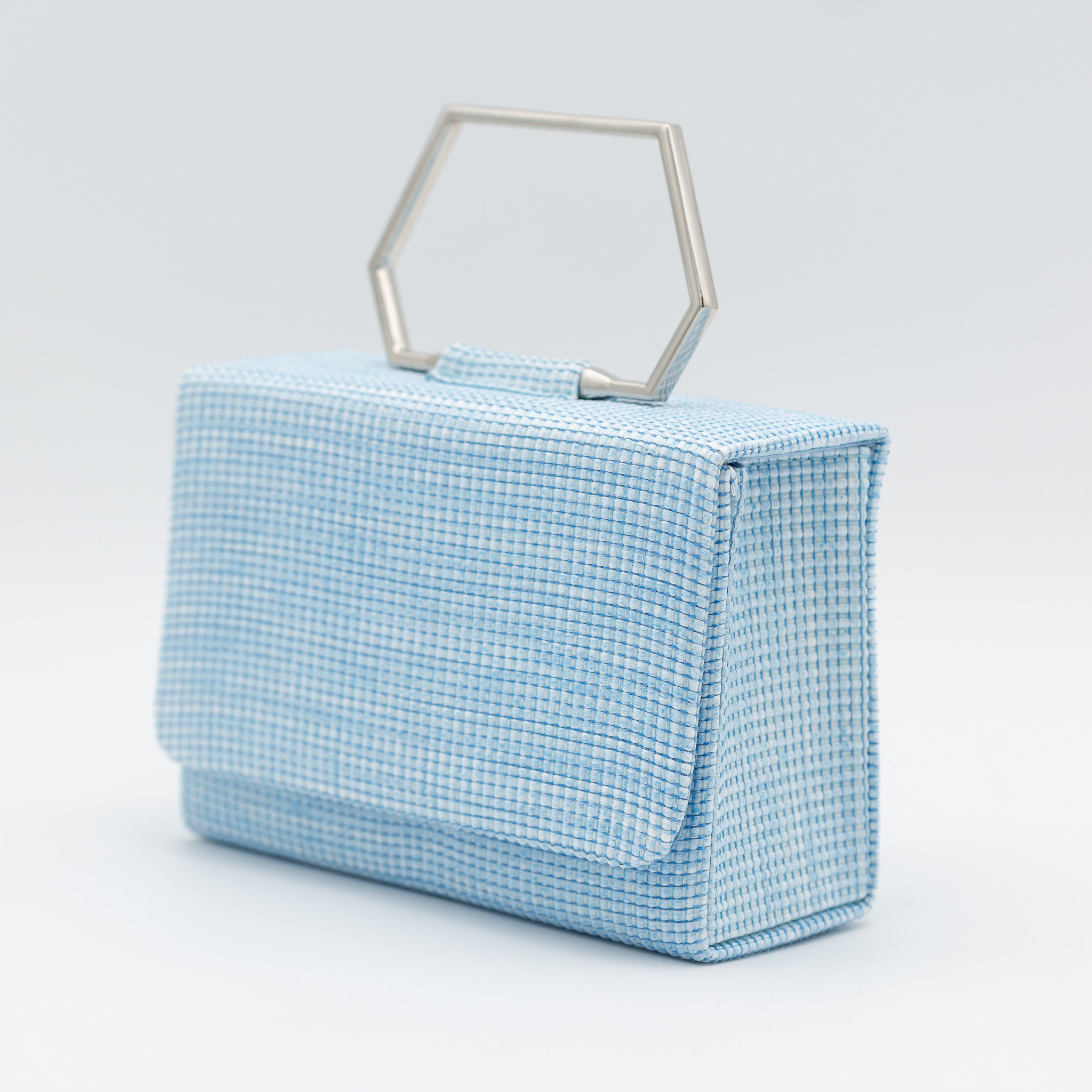 Clutch de fiesta en rafia celeste con asa geométrica metálica y cierre magnético, ideal para bodas y cócteles