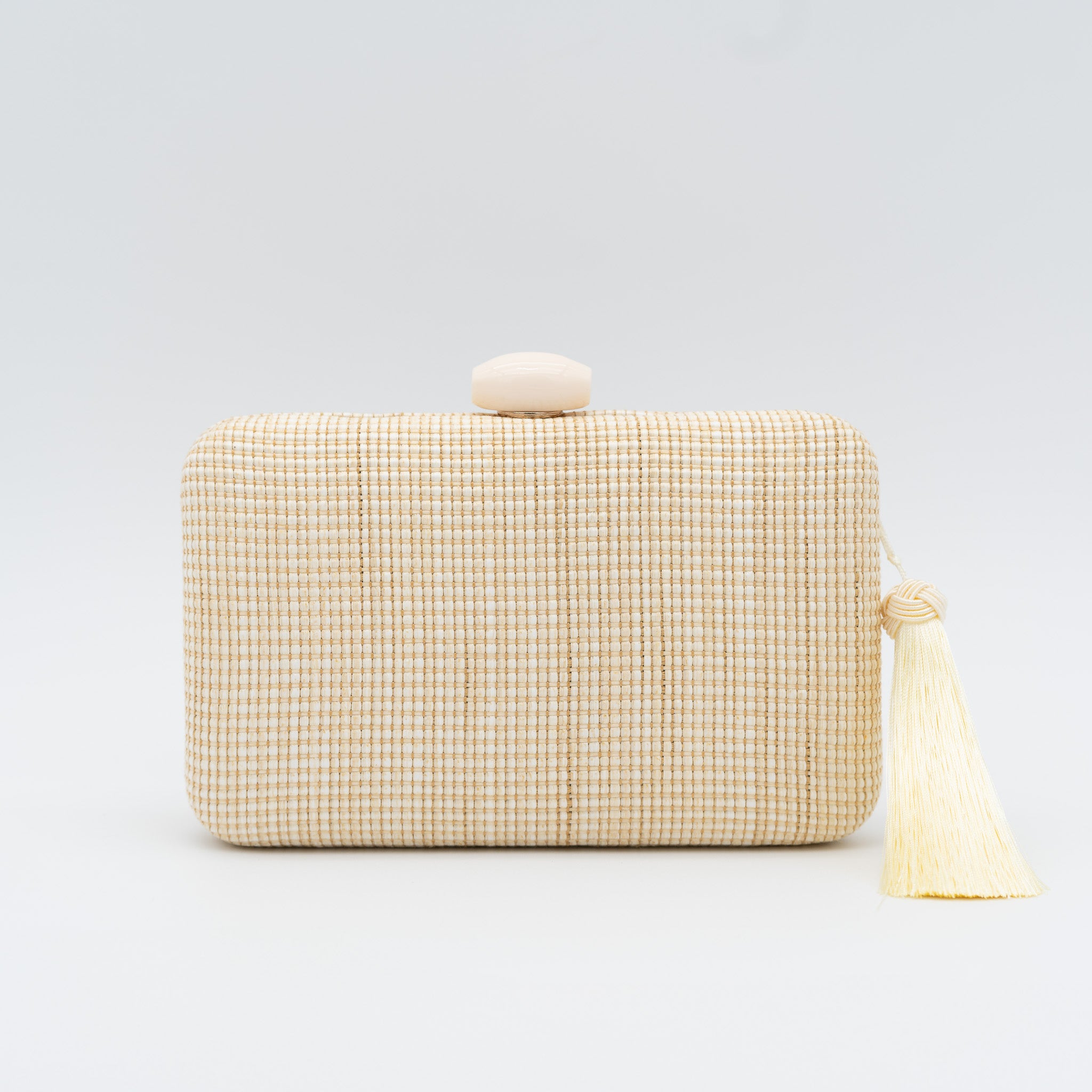 Bolso clutch de fiesta de rafia con broche ovalado en la parte superior y borla lateral en color beige