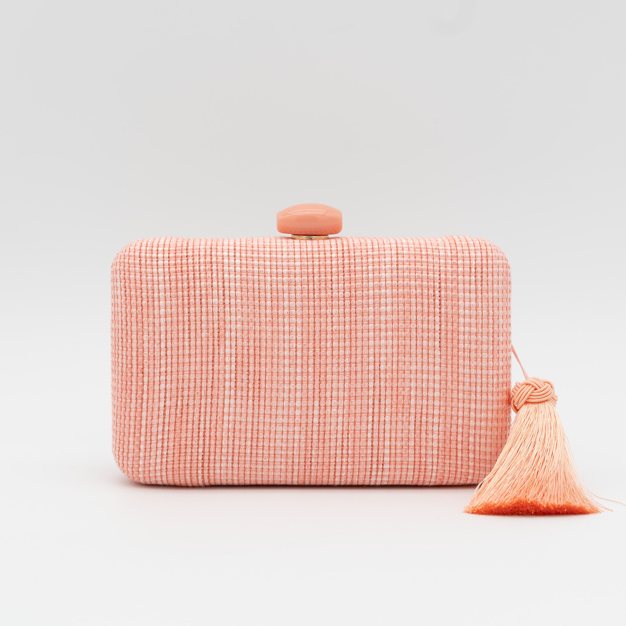 Bolso clutch de fiesta de rafia con broche ovalado en la parte superior y borla lateral en color melocotón