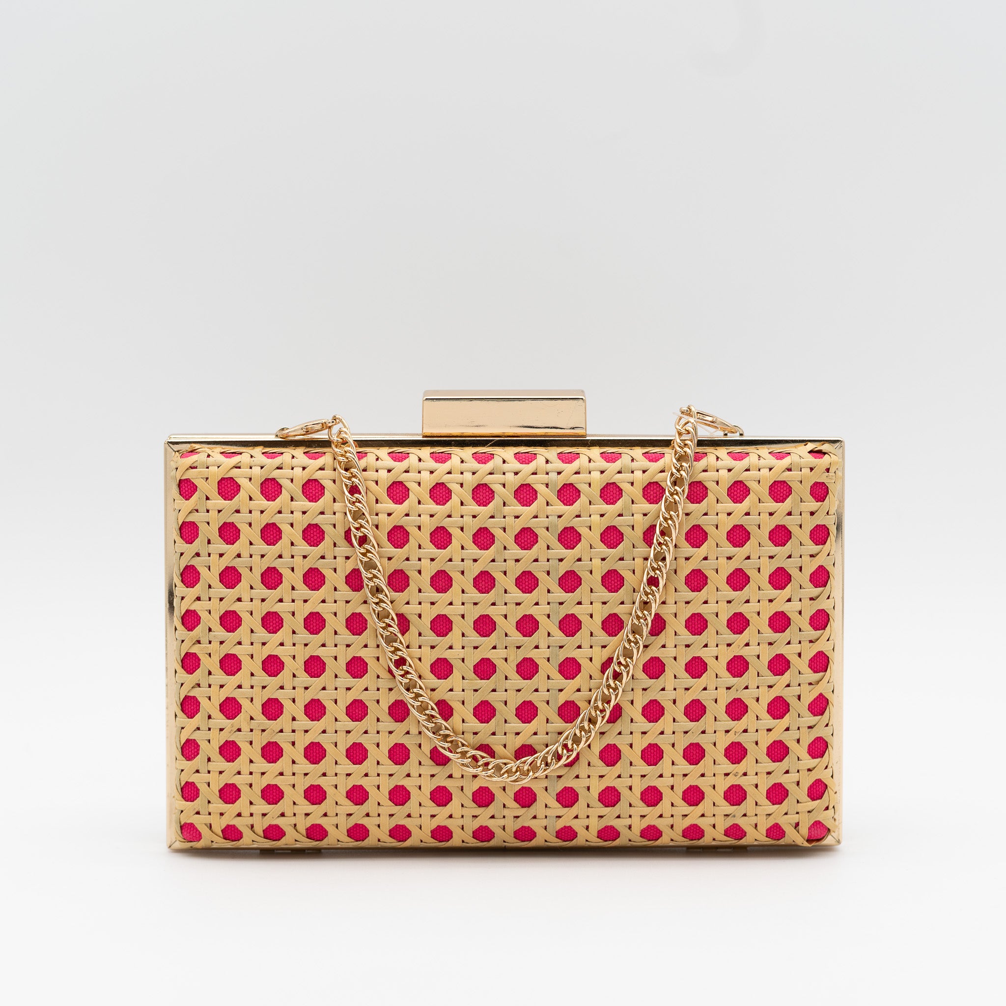 Clutch de fiesta en rafia fucsia con diseño troquelado, marco metálico y cadena desmontable, ideal para bodas y cócteles