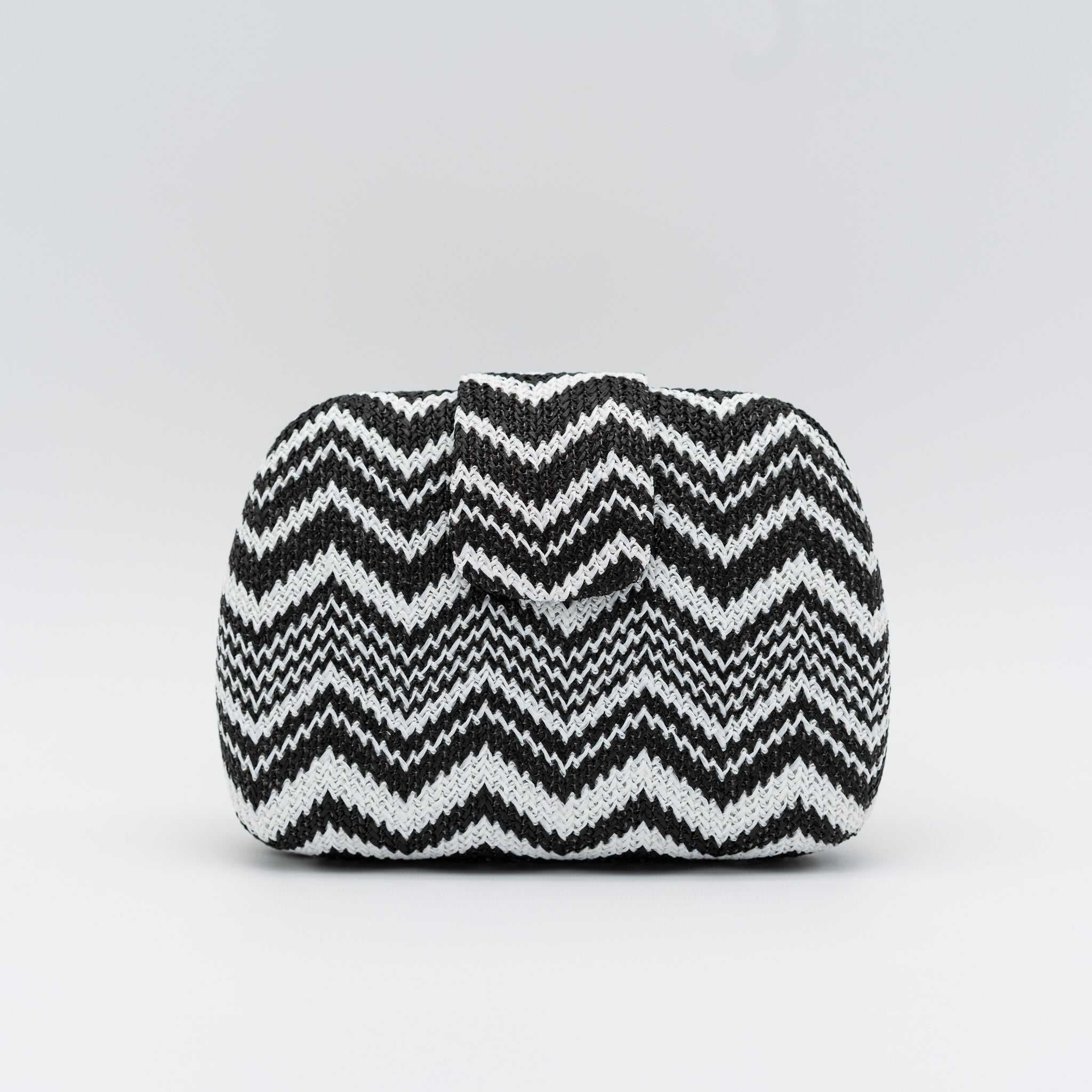 Clutch de fiesta en rafia con patrón zigzag negro blanco, cierre superior y cadena desmontable
