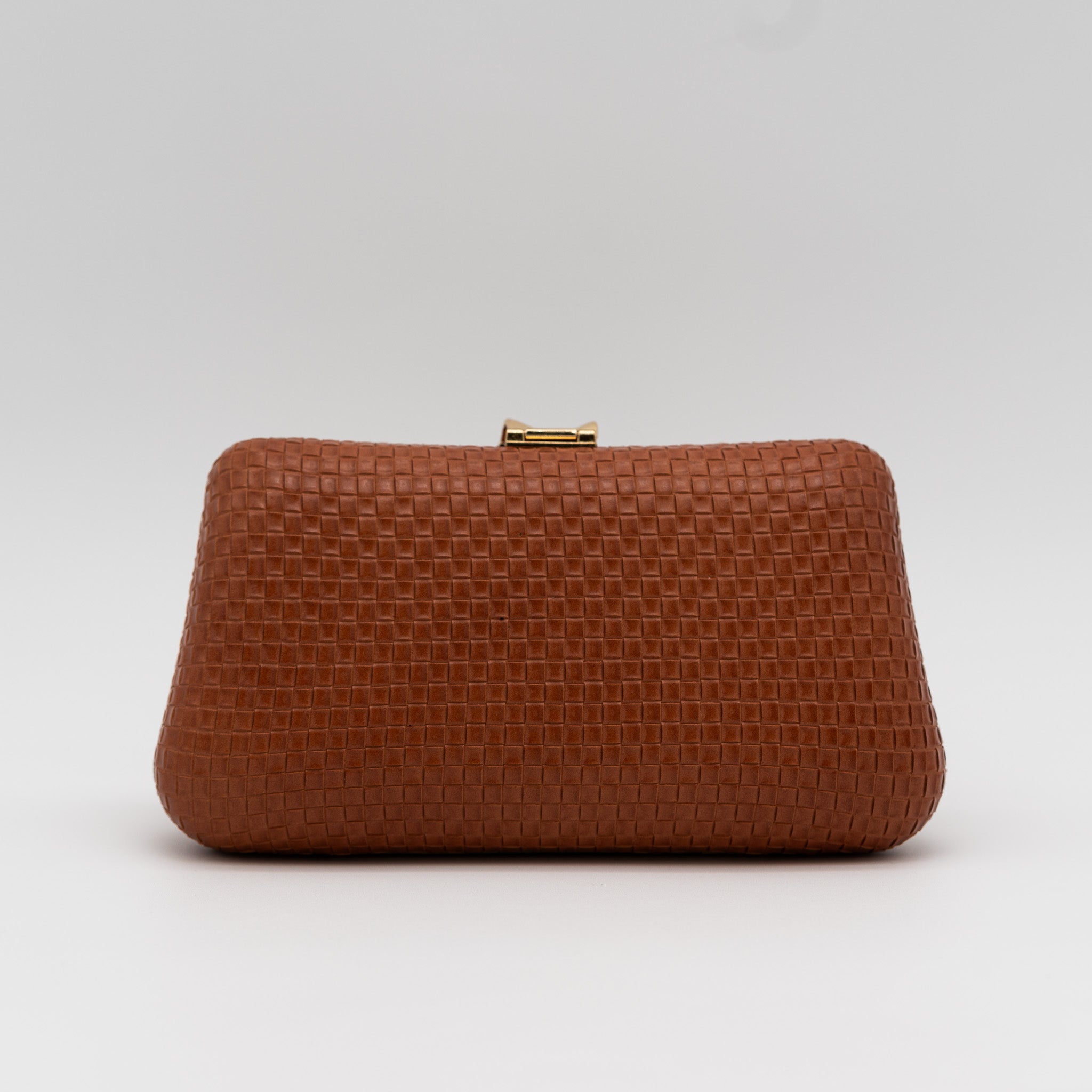 Parte trasera de bolso clutch de fiesta con textura cuadriculada color cuero y broche metálico dorado