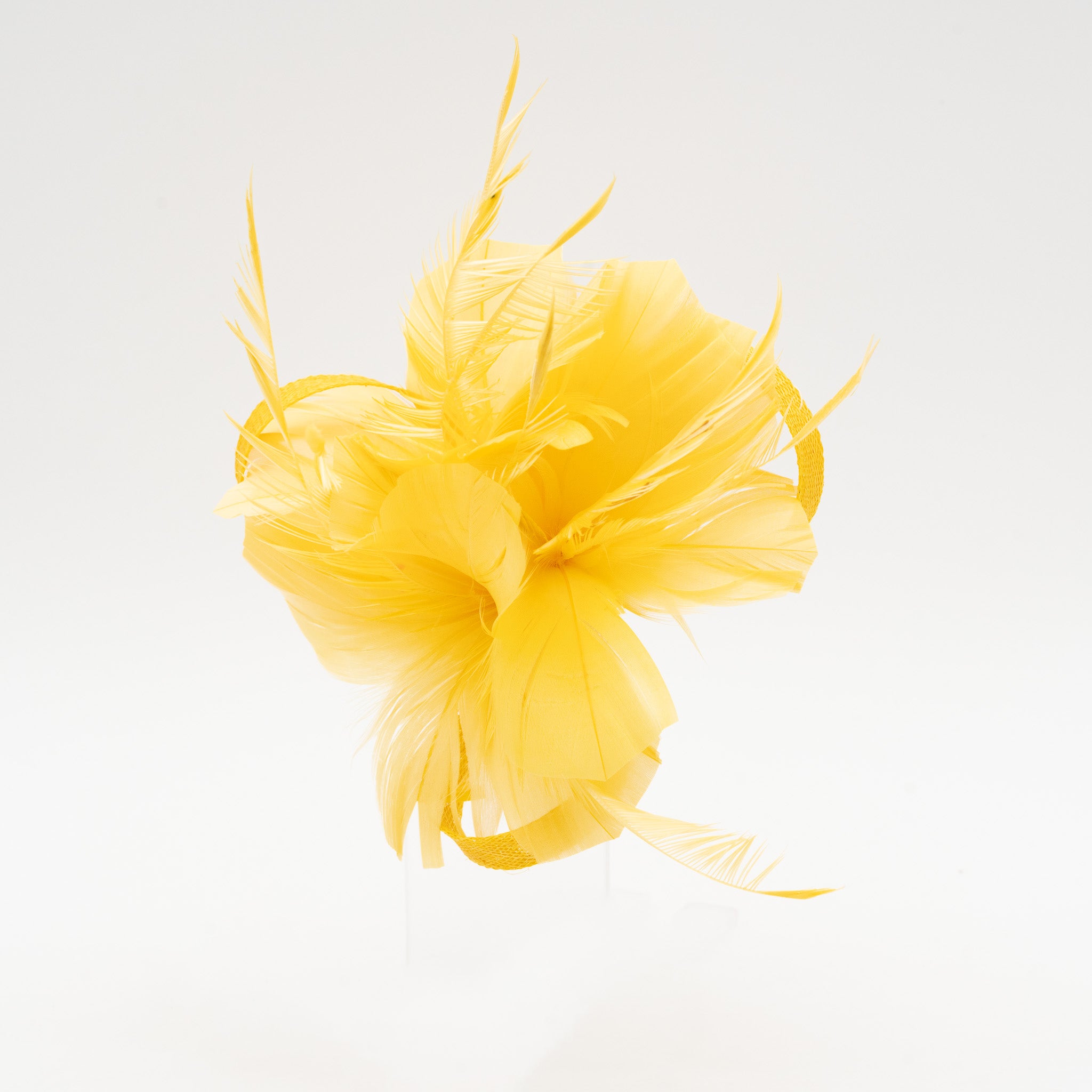 Tocado pequeño amarillo adornado con plumas elegantes, ideal para eventos especiales