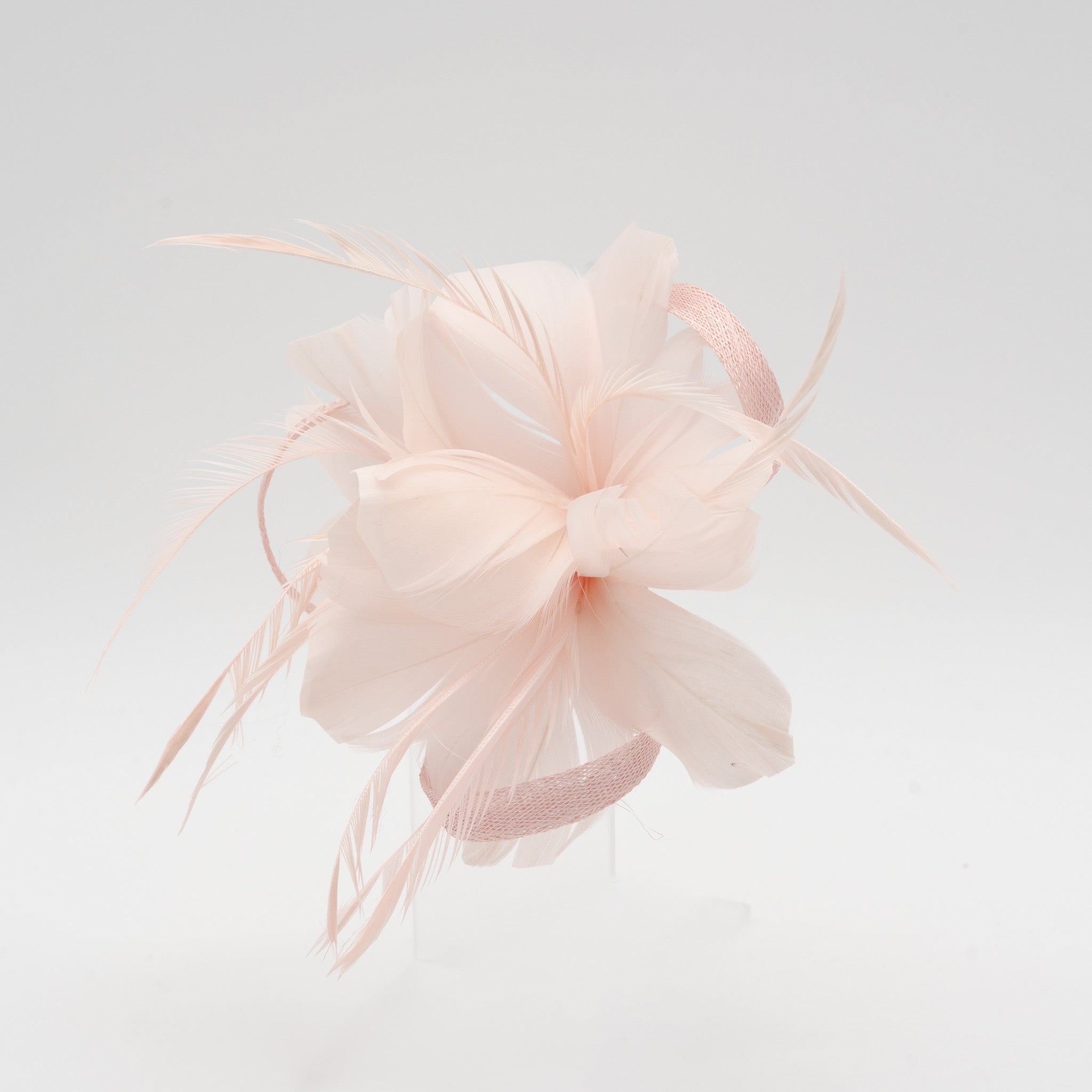 Tocado pequeño rosa adornado con plumas elegantes, ideal para eventos especiales