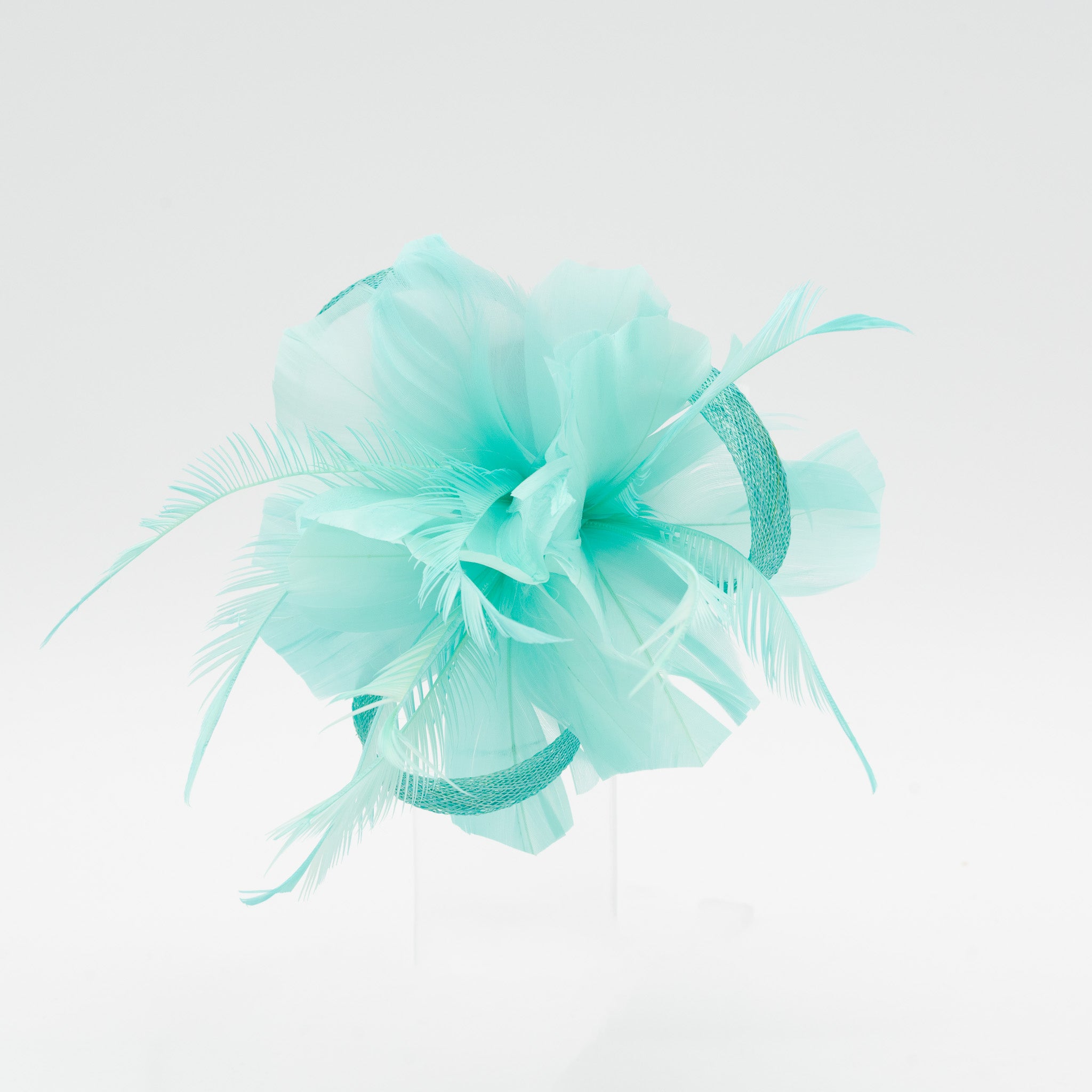 Tocado pequeño verde agua adornado con plumas elegantes, ideal para eventos especiales