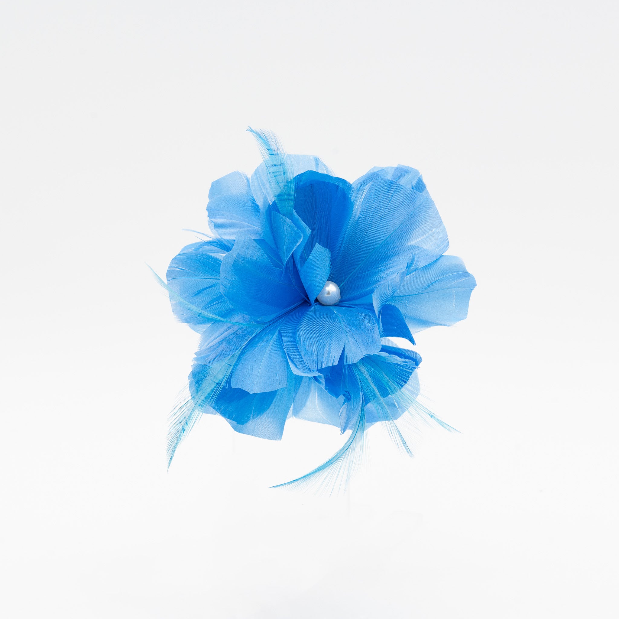 Tocado de fiesta pequeño turquesa de plumas con detalle de perla y sujeción con pinza y broche