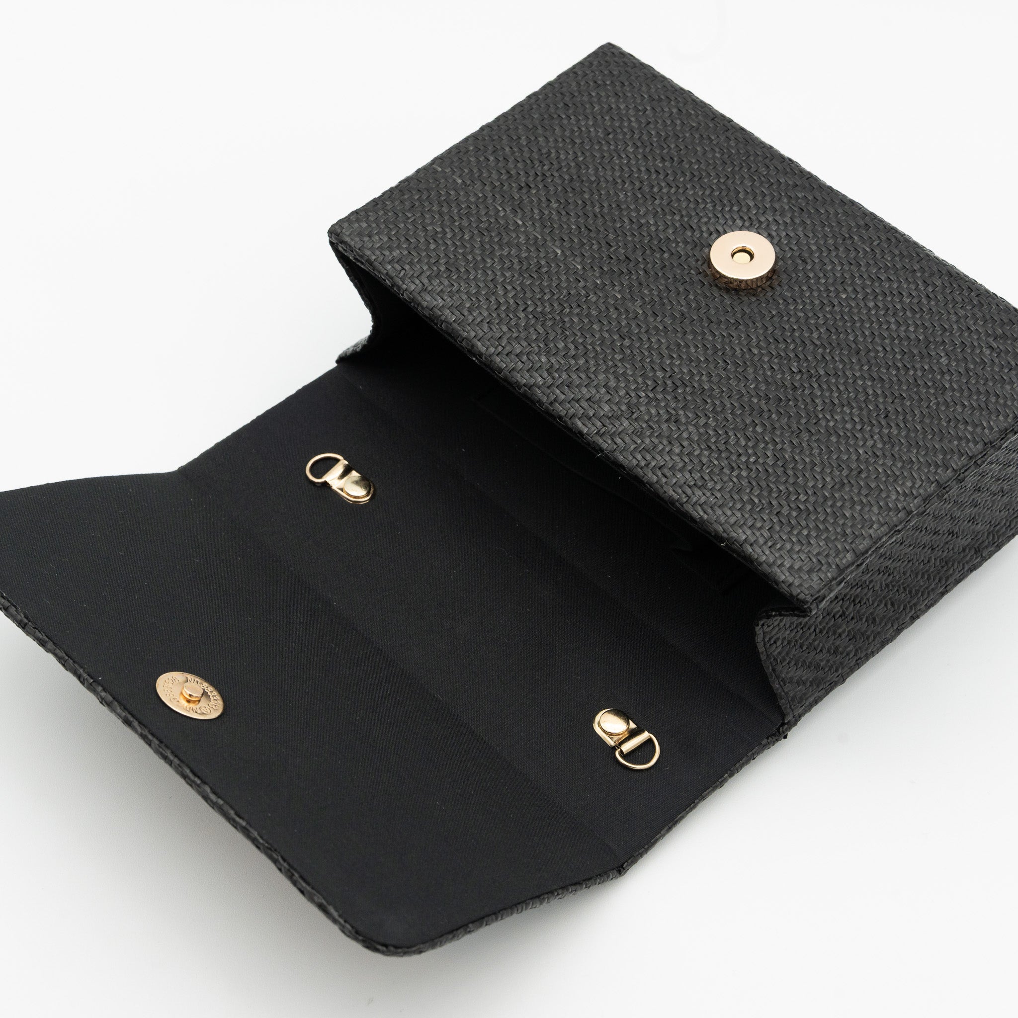 Clutch de fiesta en rafia negro con asa geométrica metálica y cierre magnético, perfecto para bodas y cócteles