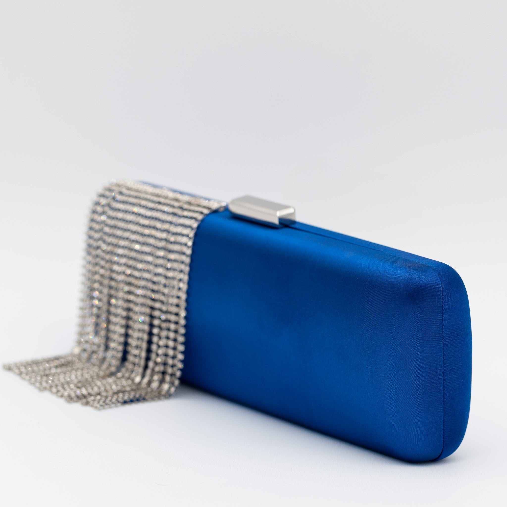 Clutch de fiesta en raso con flecos de pedrería, cierre metálico y diseño rectangular en azulón